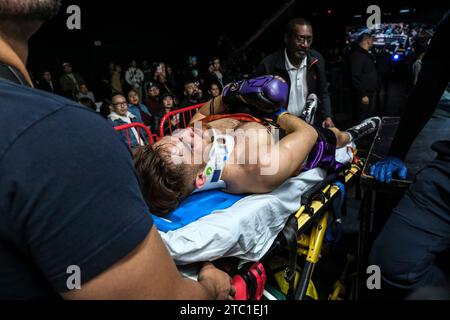 Long Beach, Kalifornien, USA. Dezember 2023. Sanitäter-Bahre Isaac Avelar aus dem Ring, nachdem er von dem früheren Federgewicht-Champion Mark Magsayo geschlagen wurde. (Kreditbild: © Adam DelGiudice/ZUMA Press Wire) NUR REDAKTIONELLE VERWENDUNG! Nicht für kommerzielle ZWECKE! Quelle: ZUMA Press, Inc./Alamy Live News Stockfoto