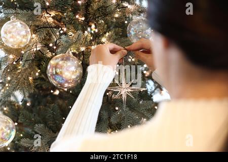 Frau schmücken den Weihnachtsbaum Stockfoto