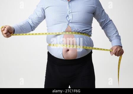 Isolierter Schuss eines adipösen Mannes, der ein enges Hemd trägt Stockfoto