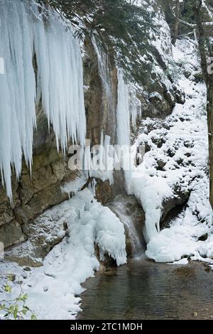 Eiszapfen. Das Einfrieren des Wassers im Fluss im Winter. Majestätische Eiszapfen hängen von der Klippe. Kalte Wintertextur. Atmosphärischer natürlicher Hintergrund Stockfoto