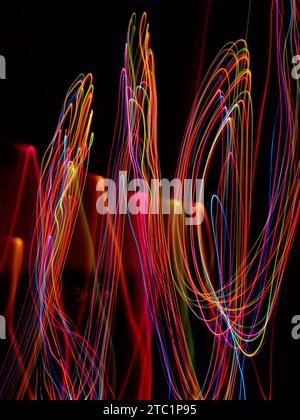 Lange Belichtungswege mit rosa, orangefarbenem, gelbem und blauem Licht Stockfoto