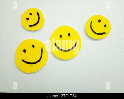 Handgefertigte Smiley-Symbole auf weißem Hintergrund. Glücklich, Freude, Lächeln, positive Vibes, zusammen, gemeinschaft, Liebe und Gruppen von Happy People-Konzepten Stockfoto