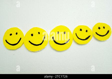Handgefertigte Smiley-Symbole auf weißem Hintergrund. Glücklich, Freude, Lächeln, positive Vibes, zusammen, gemeinschaft, Liebe und Gruppen von Happy People-Konzepten Stockfoto
