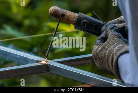 Rote heiße Schweißraupe, Naht von SMAW beim Schweißen durch Verflüssigung des Metalls. Stockfoto