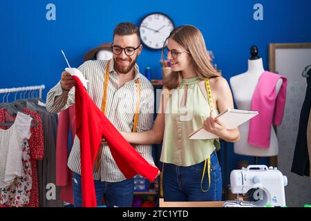 In der Bekleidungsfabrik Schneiderinnen und Schneiderinnen, die T-Shirt im Look halten Stockfoto
