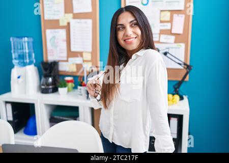Eine junge, wunderschöne arabische Geschäftsfrau, die selbstbewusst lächelt und am Schreibtisch auf der Straße steht Stockfoto