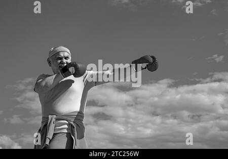 Schöner älterer Mann, der Boxkick übt. Älterer sportlicher Mann im Boxsport, der Übungen mit Boxhandschuhen macht. Ich liebe Boxen. Stockfoto