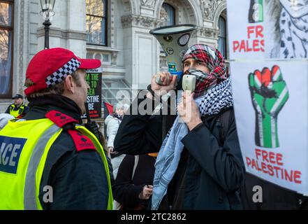 London, Großbritannien. 21. Oktober 2023: Ein pro-palästinensischer Demonstrant in Whitehall ruft in ein Megaphon, kurz bevor er von der Polizei verhaftet wird, weil er remo verweigert hat Stockfoto