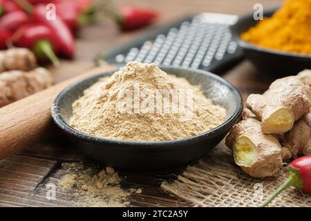 Schüssel mit Ingwerpulver und frischen Ingwerwurzeln. Kurkuma und rote heiße Paprika auf dem Hintergrund. Aromatische Gewürze. Zutaten zum Kochen und Stockfoto