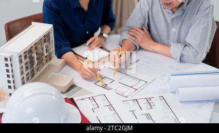 Zwei Architekten analysieren und planen den Bau eines Bauprojekts auf der Grundlage eines Bauplans. Stockfoto