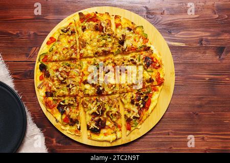 St. Pizza im Louis-Stil, hausgemacht auf hölzernem Hintergrund, mit Käse, Pfeffer, Speck, Zwiebeln Stockfoto