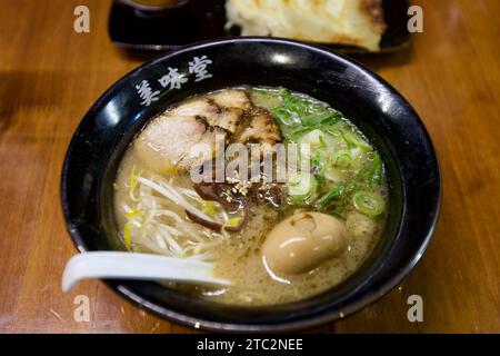 Eine köstliche Schüssel Ramen, kunstvoll präsentiert mit einem sanft pochierten Ei in Wasser, saftigem Fleisch darauf und perfekt gekochten Nudeln, um ein sav zu schaffen Stockfoto