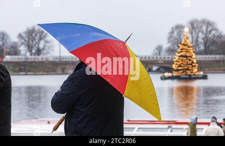 Hamburg, Deutschland. Dezember 2023. Ein Mann steht unter seinem Schirm im Nieseln auf der inneren Alster. Quelle: Markus Scholz/dpa/Alamy Live News Stockfoto