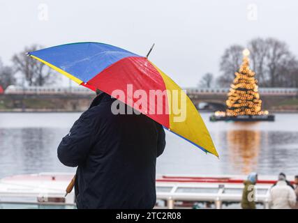 Hamburg, Deutschland. Dezember 2023. Ein Mann steht unter seinem Schirm im Nieseln auf der inneren Alster. Quelle: Markus Scholz/dpa/Alamy Live News Stockfoto