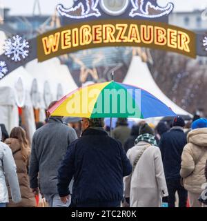 Hamburg, Deutschland. Dezember 2023. Ein Mann läuft mit seinem Schirm durch einen Weihnachtsmarkt im Nieseln. Quelle: Markus Scholz/dpa/Alamy Live News Stockfoto