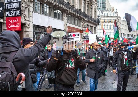 London / Großbritannien - 9. Dezember 2023: Ein pro-palästinensischer muslimischer Demonstrant benutzt ein Megaphon und andere sangen bei einer Demonstration, die ein Ende des israelischen Angriffs fordert Stockfoto