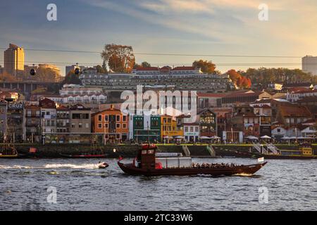 Porto, Porugal - 13. November 2021: Die Architektur des Stadtteils Ribeira und ein Boot für Touristen vom Fluss Douro aus gesehen Stockfoto