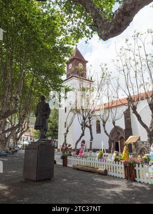 Machico, Madeira, Portugal, 17. Mai 2022: Fußgängerzone im Zentrum der Stadt Machico mit Platanen, Blumenschmuck und Häusern auf traditionellem p Stockfoto