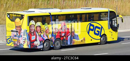 Werbegrafiken für Abenteuerreisen für Schulkinder auf der Seite und Rückseite des Reisebusses auf der Autobahn M25 Essex England UK Stockfoto