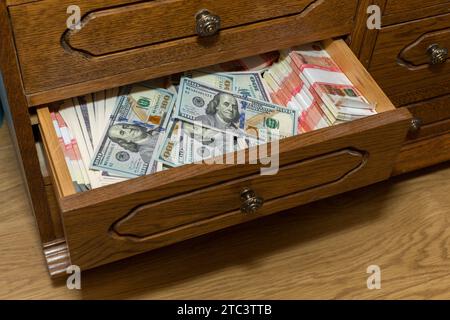 Einsparungen in Dollar und in russischen Rubel von je fünftausend, in einem alten Schrank gelagert. Eine große Menge Geld in bar. Stockfoto