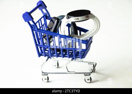 Dnipro, Ukraine - 10. Dezember 2023: Smart Watch Samsung Galaxy Active Watch weiß und schwarz Apple Watch Series 8 liegen in einem kleinen Wagen von einem Supermark Stockfoto