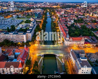 Aus der Vogelperspektive auf das Ufer des Bega River und die Brücke von Stephen the Great zur blauen Stunde. Drohnenfoto, aufgenommen am 7. September 2023 in Timisoara, Bezirk Timis, Stockfoto