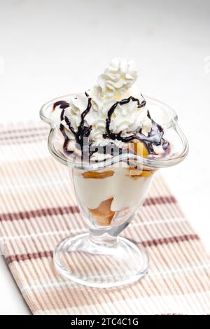 Eis mit geschmorten Pfirsich und Schlagsahne Stockfoto