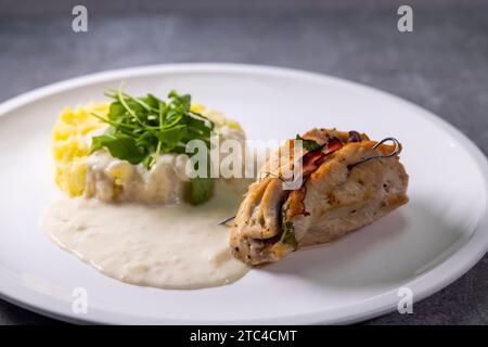 truthahnbrötchen gefüllt mit Spinat und Schinken serviert mit Kartoffelpüree und Sahne Sauce Stockfoto