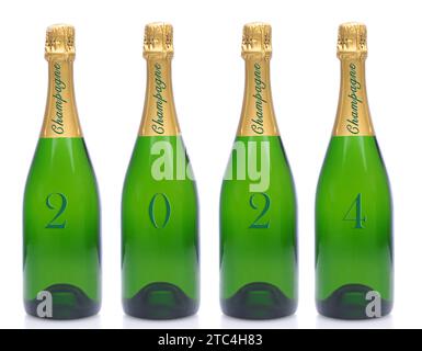 Neujahrskonzept. 4 Flaschen Champagner mit dem Datum 2024, eine Nummer pro Flasche, auf weißem Hintergrund. Stockfoto