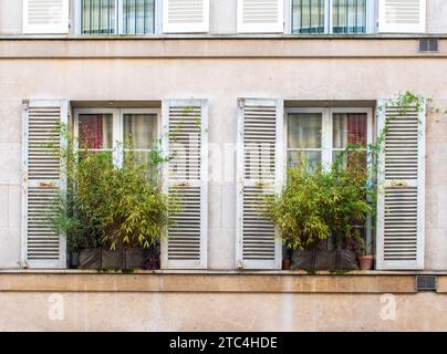 Fenster mit Lüftungsschlitzen an der Fassade eines alten Gebäudes Stockfoto