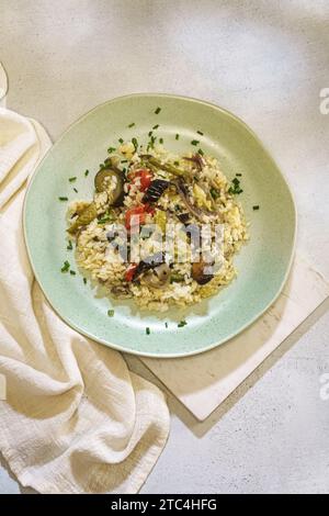 Gesunder Reis mit Gemüse auf grüner Platte auf hellem Hintergrund. Draufsicht. Stockfoto