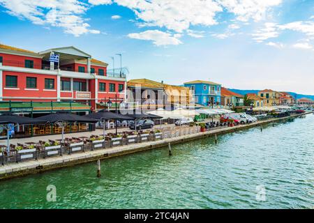 Lefkada Stadt Uferpromenade, Blick auf das Ionische Meer Griechenland. Farbenfrohe Häuser, Restaurants und Tische auf dem Bürgersteig entlang der Küstenstraße auf der Insel Lefkada Stockfoto