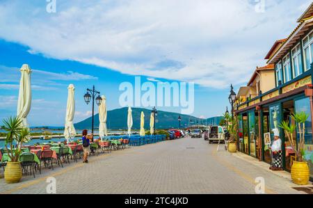 Lefkada Stadt Uferpromenade, Blick auf das Ionische Meer Griechenland. Farbenfrohe Häuser, Restaurants und Tische auf dem Bürgersteig entlang der Küstenstraße auf der Insel Lefkada Stockfoto