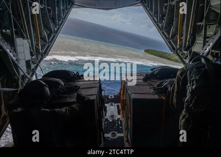 (Von links nach rechts) der Senior Airman Ian Munoz, 36th Expeditionary Airlift Squadron Loadmaster, und Senior Airman John Douglas, 36th EAS Loadmaster, hocken sich zusammen, um humanitäre Hilfe-Luftabwurfbündel in Oneop, Föderierte Staaten von Mikronesien, am 3. Dezember 2023 zu veröffentlichen, um die Operation Christmas Drop 2023 (OCD 23) zu unterstützen. Veranstaltungen wie OCD 23 ermöglichen es uns, den abgelegenen Bevölkerungsgruppen die notwendige Hilfe zu leisten und gleichzeitig die Möglichkeit zu bieten, auf Notfälle in der realen Welt vorbereitet zu sein. (Foto der U.S. Air Force von Senior Airman Brooklyn Golightly) Stockfoto