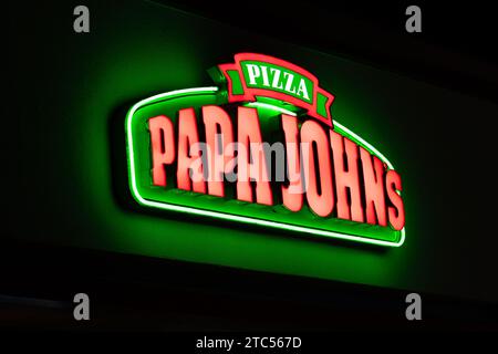 STILLWATER, MN, USA - 7. DEZEMBER 2023: Schild mit dem beleuchteten Restaurant von Papa John in Night und Markenlogo. Stockfoto