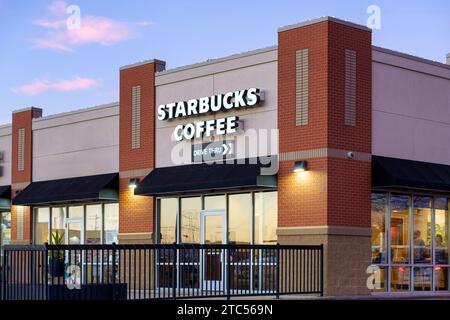 STILLWATER, MN, USA - 7. DEZEMBER 2023: Starbucks Coffee Restaurant in der Abenddämmerung und Markenlogo. Stockfoto