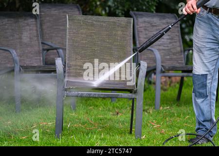 Reinigung von Außenmöbeln mit einem Wasserstrahler Stockfoto