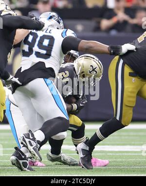 New Orleans, USA. Dezember 2023. New Orleans Saints Running Back Jamaal Williams (21) stürzt sich auf eine harte Strecke, während Carolina Panthers Defensive Tackle Shy Tuttle (99) während eines Spiels der National Football League im Caesars Superdome in New Orleans, Louisiana am Sonntag, den 10. Dezember 2023, in Angriff genommen wird. (Foto: Peter G. Forest/SIPA USA) Credit: SIPA USA/Alamy Live News Stockfoto