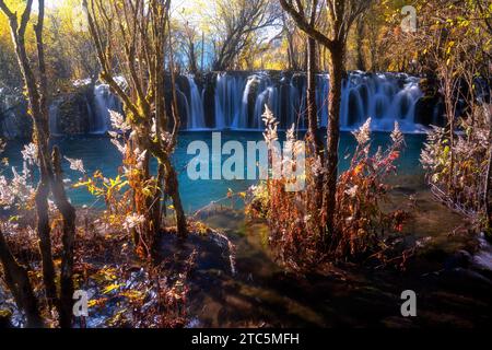 Wunderschöne und frische Landschaft am Arrow Bamboo Wasserfall mit Kaskade, grünen Algen, Reflexionen und Bäumen, perfekt für Entspannung während des Urlaubs im Jiu Stockfoto