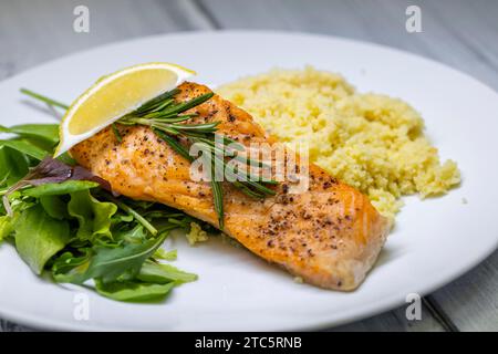 Gegrillter Lachs serviert mit Couscous und Gemüsesalat Stockfoto