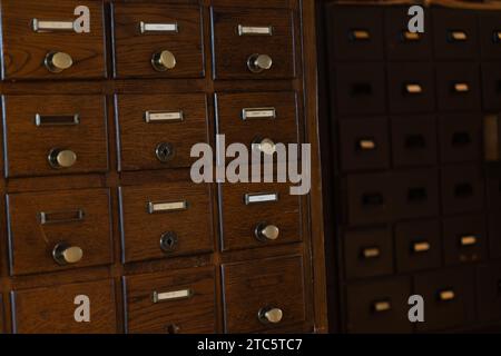 Ein Holzschrank mit mehreren Schubladen in einem mit Holzmöbeln gefüllten Raum Stockfoto