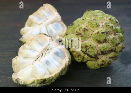 Nahaufnahme von süßem und saftigem Fleisch und ganzen Früchten von Zucker Apfel oder Süßsop Stockfoto