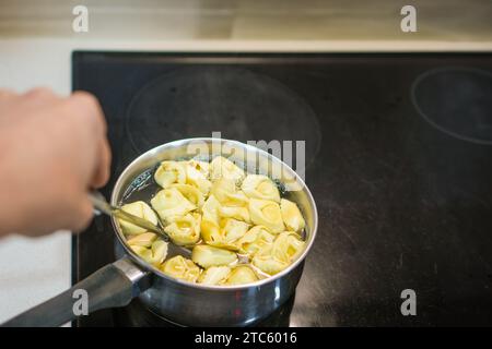 Ravioli mit Hüttenkäse und Spinat kochen in Wasser in einem Metalltopf. Stockfoto