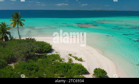 Tropischer Inselstrand mit Korallenriff kristallklarem türkisfarbenem Wasser. Frau zurück Blick im Meer stehend genießen Sie wunderschöne wilde Naturlandschaft. Gelbes Kajak. Sommerferien Stockfoto