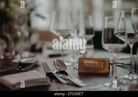 Reservierung auf dem Tisch, reserviertes Tischschild, Schild. Elegante, romantische Tischdekoration für Hochzeitsempfänge im Haus. Oder für ein Restaurant. Stockfoto