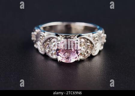 Zoom View Rosa lila Diamant Ehering auf schwarzem Hintergrund. Wunderschöner Schmuck über Beziehung, Liebe, Liebhaber oder Paar Konzept in guter Zeremonie Stockfoto