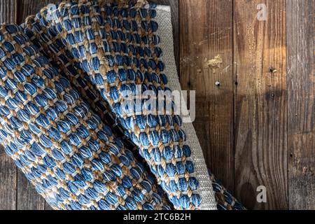 Handgewebter Teppich mit geometrischem Denim-Bereich auf Holzboden. Stockfoto