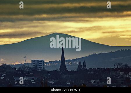 Glasgow, Schottland, Großbritannien. Dezember 2023. Wetter in Großbritannien: Bewölktes Dawn sah einen miserablen nassen windigen Tag über dem Westen der Stadt. Während der Turm des Cottiers Theatre im West End den Finger zum höchsten Punkt in Zentral-Schottland gibt, ist der Tinto Hill 40 Meilen entfernt und wegen der Opfer der Druiden durch Feuer im Hintergrund als Mount Doom bekannt. Credit Gerard Ferry/Alamy Live News Stockfoto