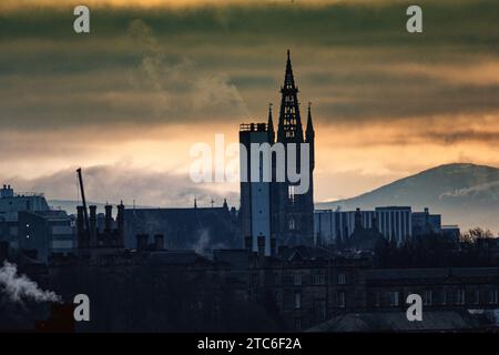 Glasgow, Schottland, Großbritannien. Dezember 2023. Wetter in Großbritannien: Bewölktes Dawn sah einen miserablen nassen windigen Tag über dem Westen der Stadt. Da der gotische Turm der Universität glasgow im westlichen Ende den höchsten Punkt in Zentral-schottland hat, ist der Tinto-Hügel 40 Meilen entfernt und wegen der Opfer der Druiden durch Feuer im Hintergrund als Mount Doom bekannt. Credit Gerard Ferry/Alamy Live News Stockfoto