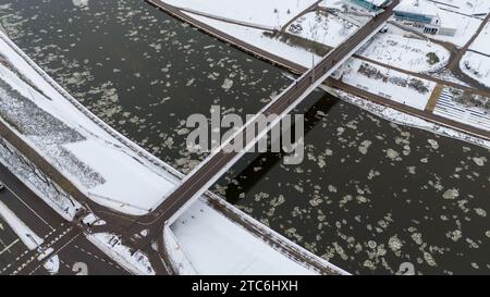 Drohnenfotografie von einer Fußgängerbrücke über einem Fluss in einer Stadt während des Winters Stockfoto